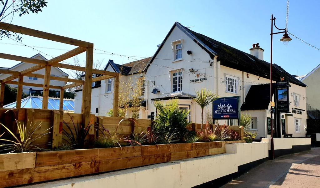 un edificio con una valla y plantas delante de él en The Eyre Court, en Seaton