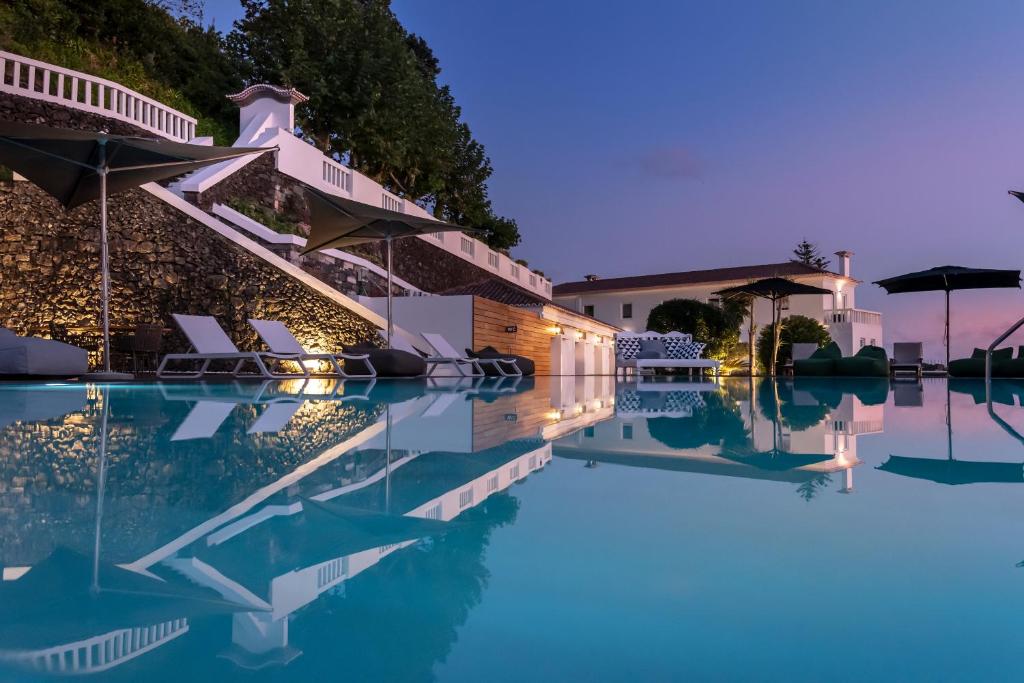 a view of the pool of a hotel at night at Quinta da Abelheira in Ponta Delgada