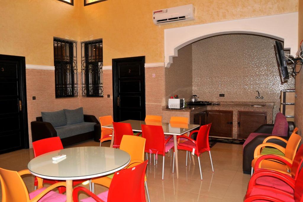 a room with tables and chairs and a kitchen at Silia in Marrakesh