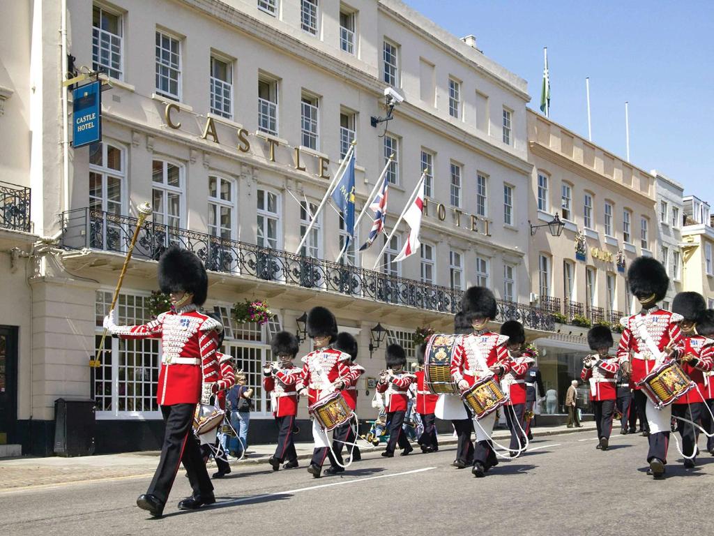 een groep kinderen in uniform die door een straat marcheren bij Castle Hotel Windsor in Windsor