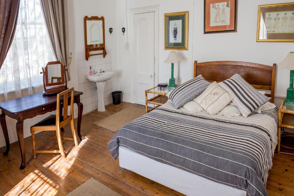 una camera con letto, scrivania e lavandino di 3 Darling Street Guest House a Hanover