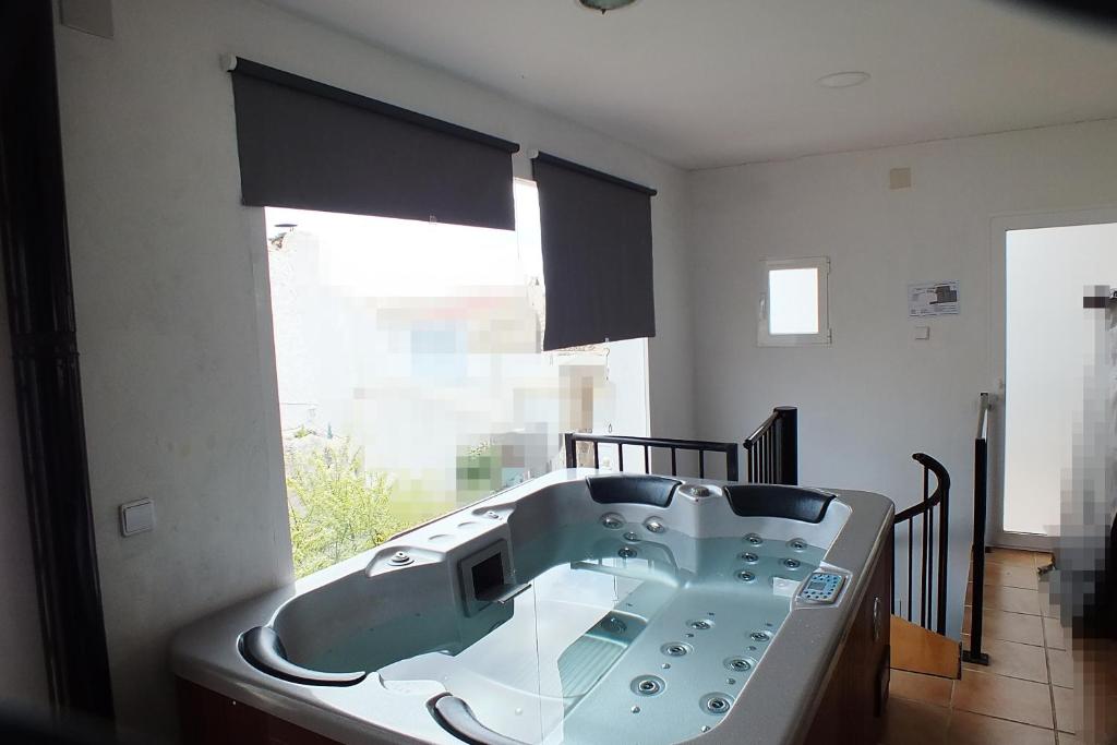 y baño con bañera y ventana. en Pensión Isla - Couples Only, en Casas de Cuadra