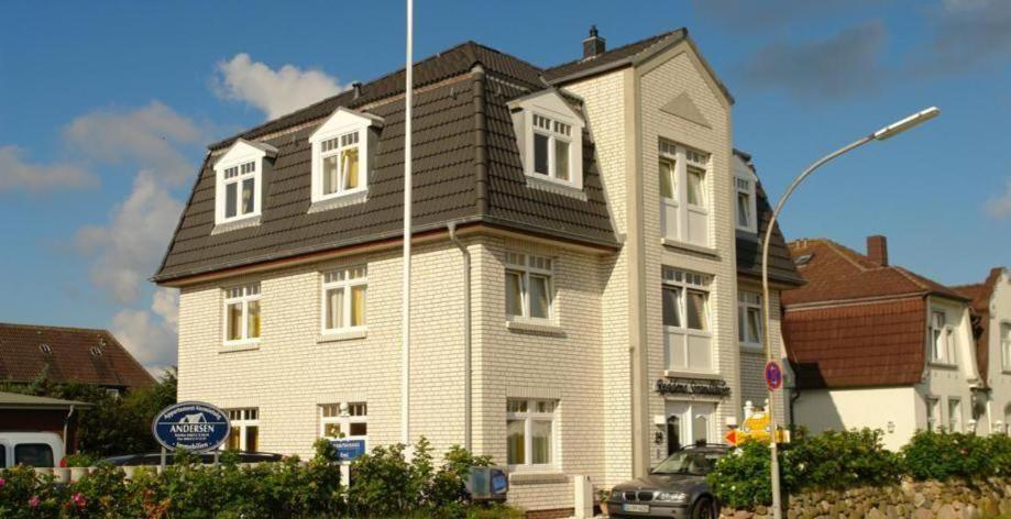 una grande casa con tetto nero su una strada di Haus-Berthin-Bleeg-App-6 a Wenningstedt