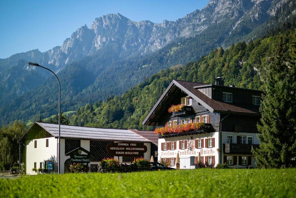 a building in a field with mountains in the background at Walch's Camping & Landhaus in Braz