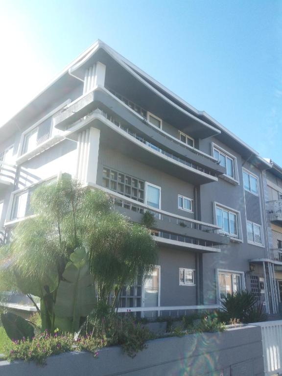 a large building with a palm tree in front of it at Buddies Charm Apt - Self Catering in Aveiro