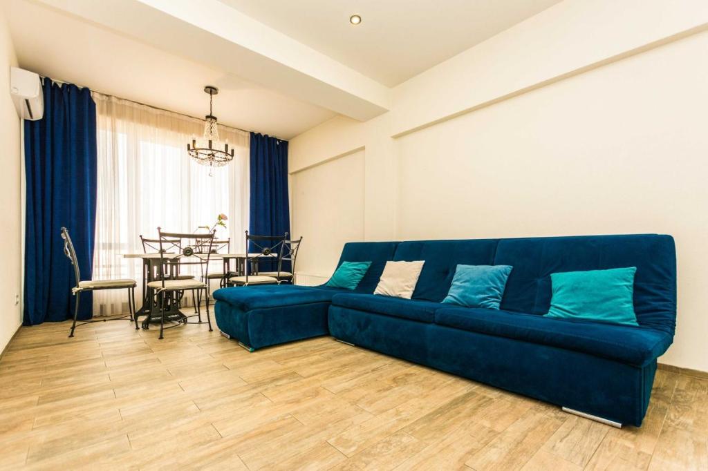 een blauwe bank in een woonkamer met een tafel bij КишиневАпартаменты in Chişinău