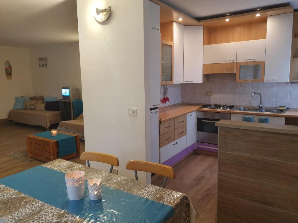 een keuken en een woonkamer met een tafel en een bank bij Moni in Aprilia Marittima