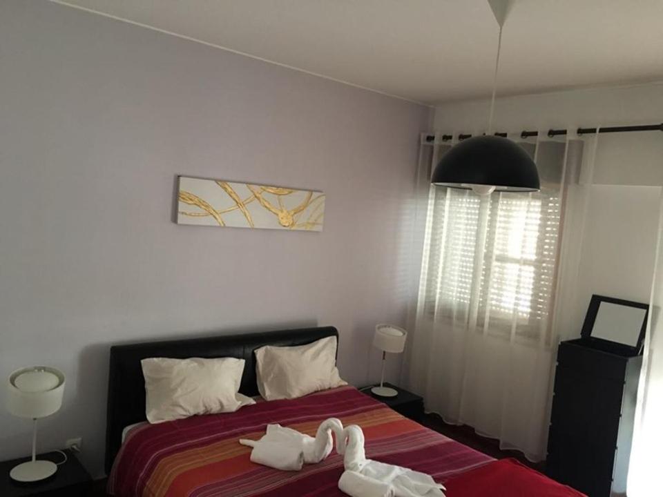 ein Schlafzimmer mit einem Bett mit weißen Handtüchern darauf in der Unterkunft CASA JUDITE in Faro