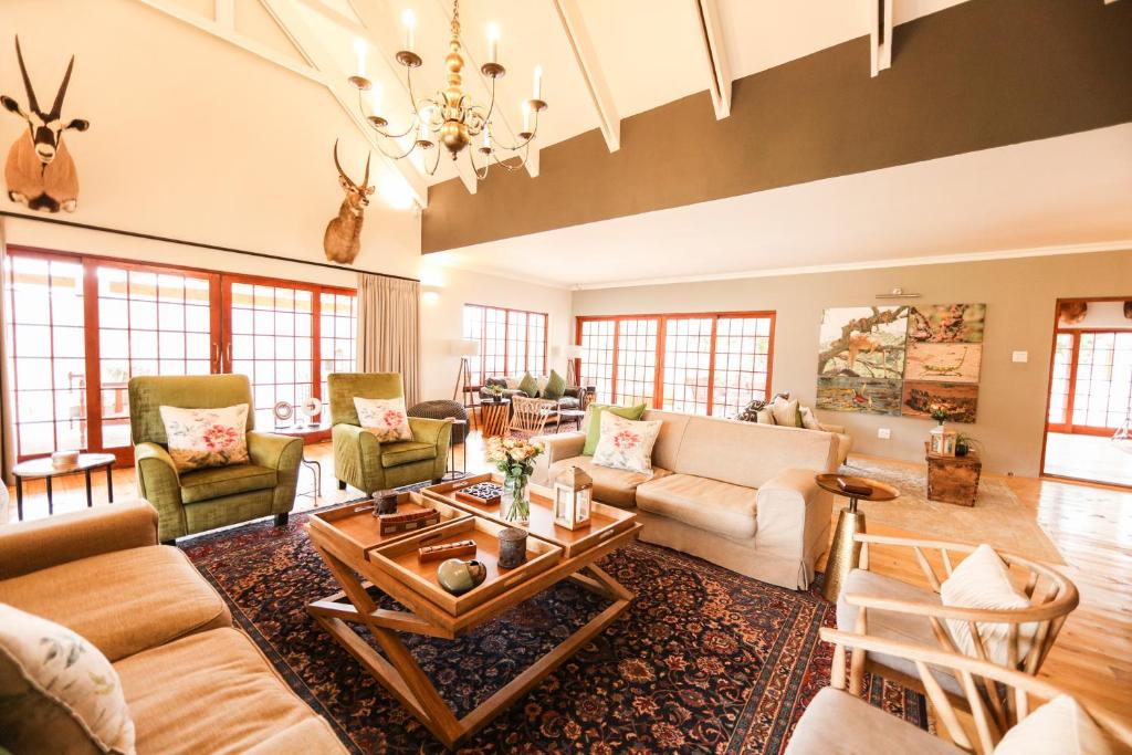 sala de estar con muebles y lámpara de araña. en Royal Karoo Safari Lodge, en Steytlerville