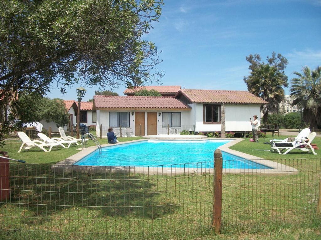 a swimming pool in front of a house at MarSerena in La Serena