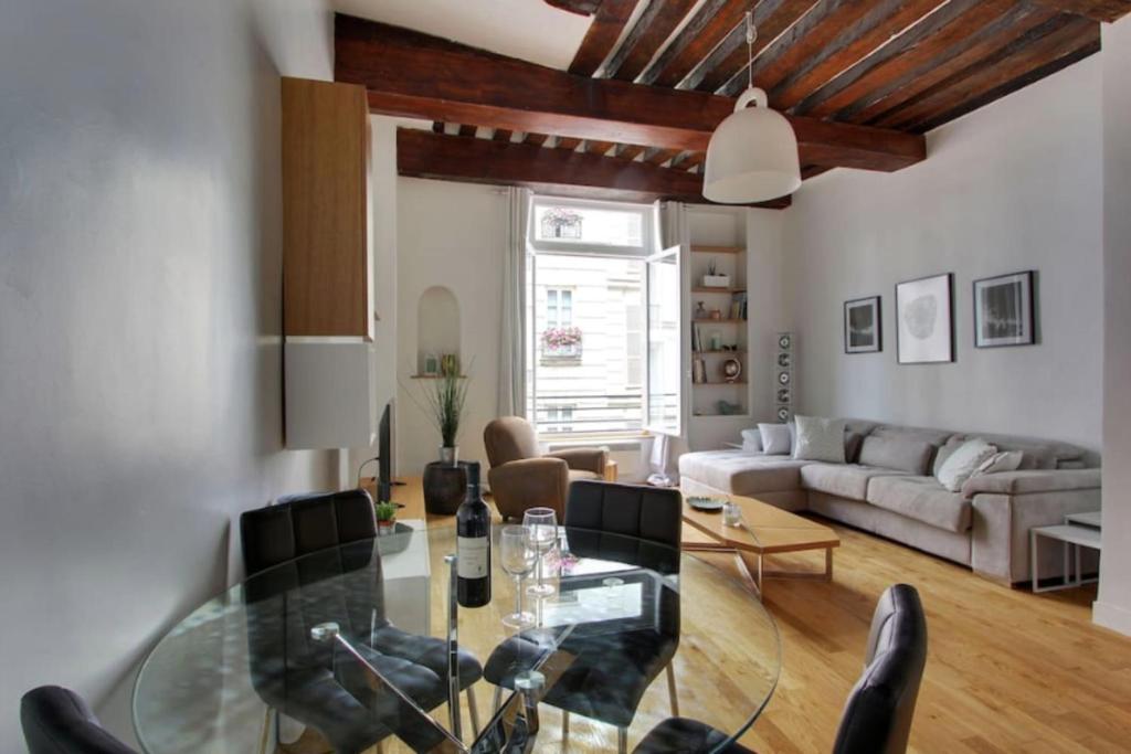 a living room with a glass table and a couch at Luminous Loft in Saint-Germain des Prés in Paris