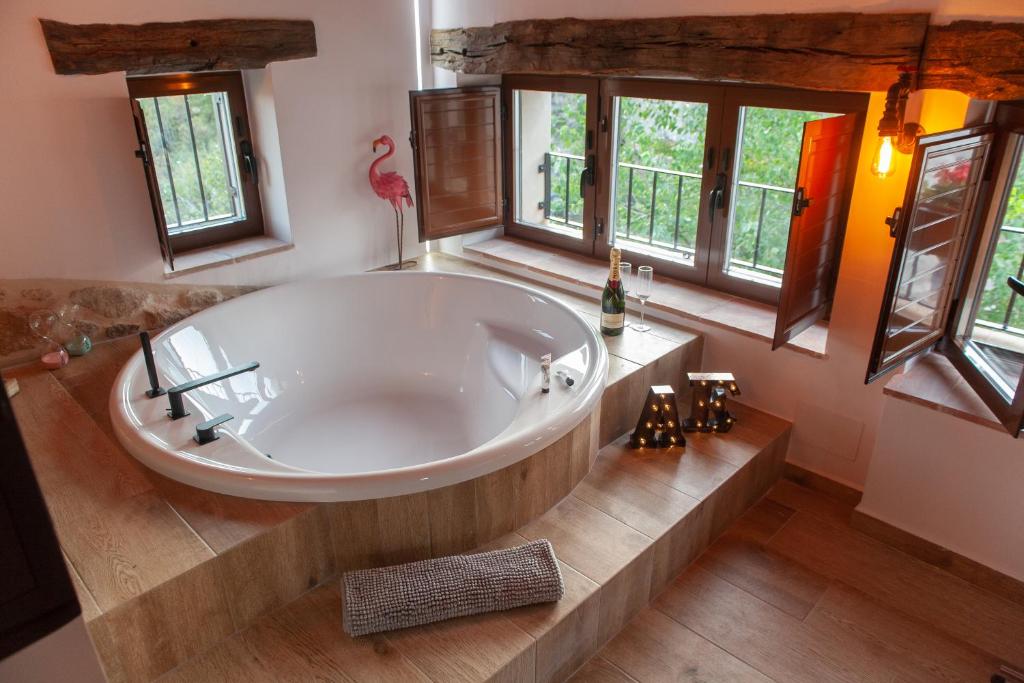 uma grande banheira branca numa casa de banho com janelas em Agua D Estrellas em Trevejo