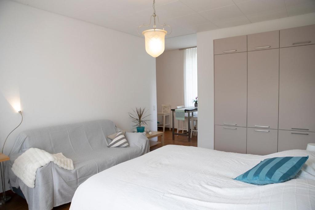 een witte slaapkamer met een bed en een kast bij Casa del Sole in Locarno
