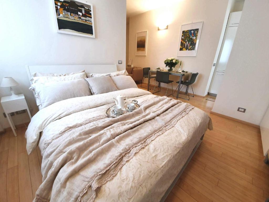 um quarto com uma cama grande e uma mesa em Corso Vercelli Apartment em Milão