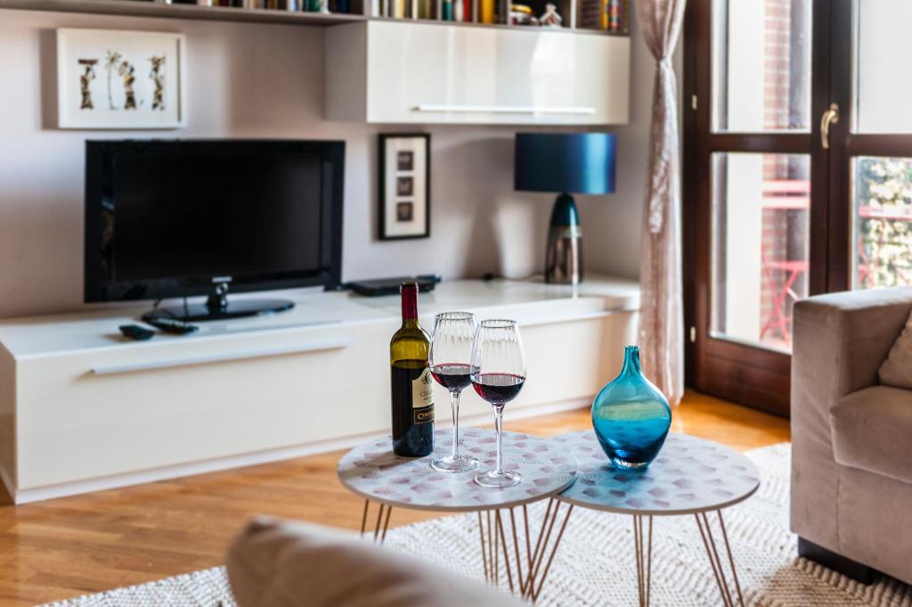 A television and/or entertainment centre at Hostly - Family Home Strada dell'Olio - Brand new 2BR, 2 Bathrooms with AC