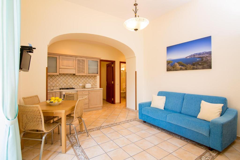 a living room with a blue couch and a table at Sine Tempore in Sorrento