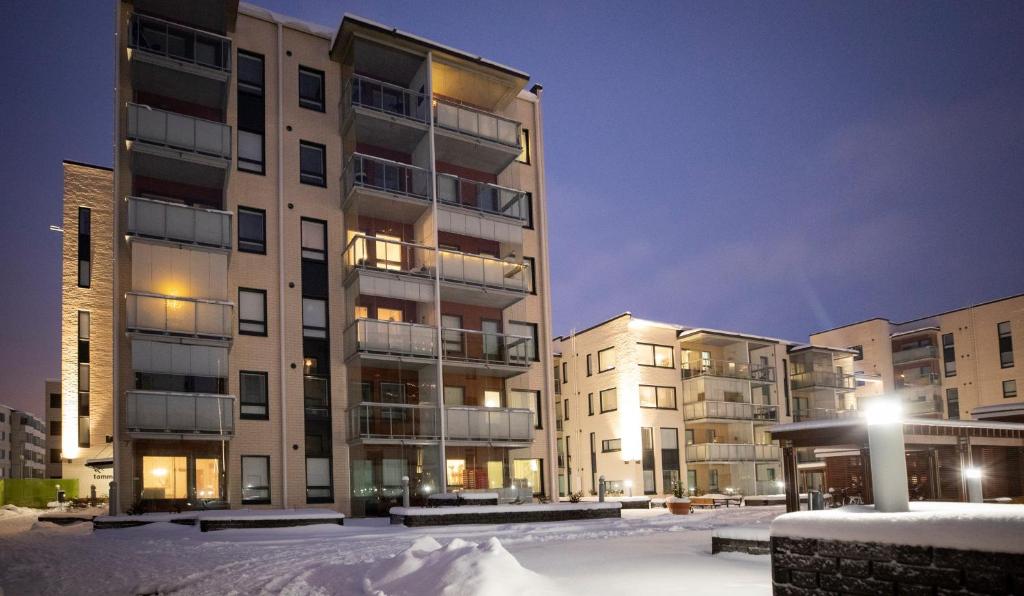 an apartment building in the snow at night at Arctic Penthouse City Suite in Rovaniemi