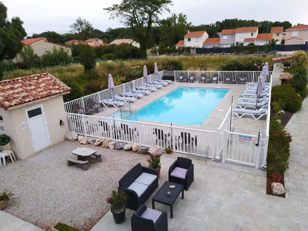 a swimming pool with chaise lounges and chairs at Hotel Bleu Azur in Argelès-sur-Mer