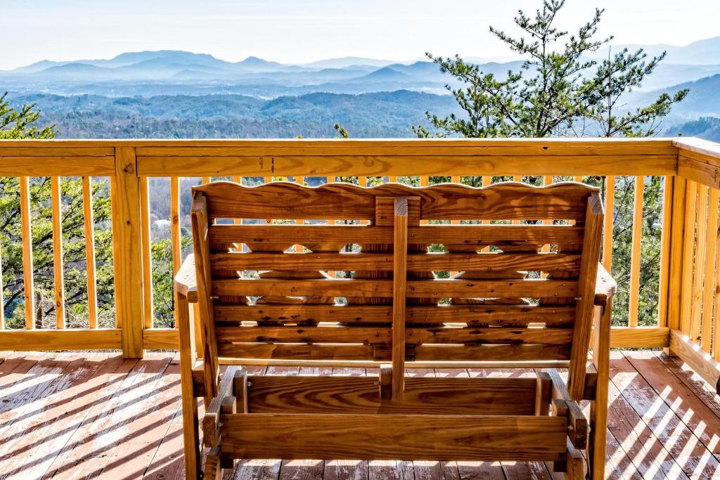 uma cadeira de madeira num deque com vista para as montanhas em #2160 Ooh Myy em Sevierville