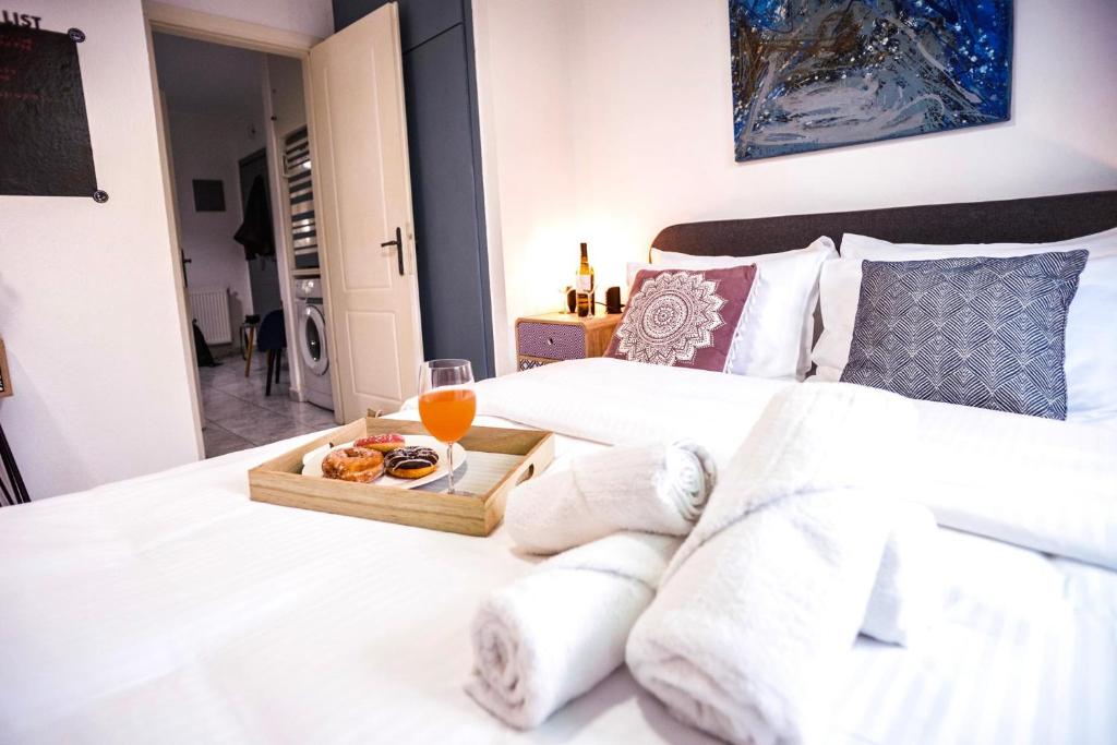 a bed with a tray of food and a glass of orange juice at Lux apartment downtown in Serres