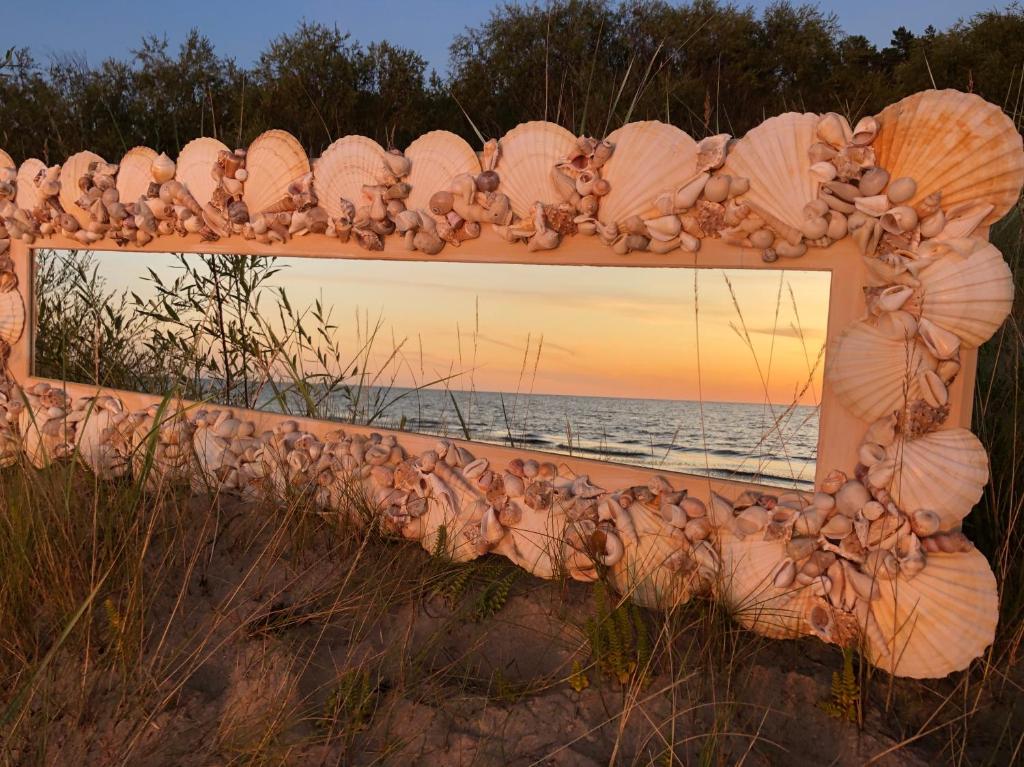 a mirror on the beach with a reflection of the ocean at Milleri in Salacgrīva