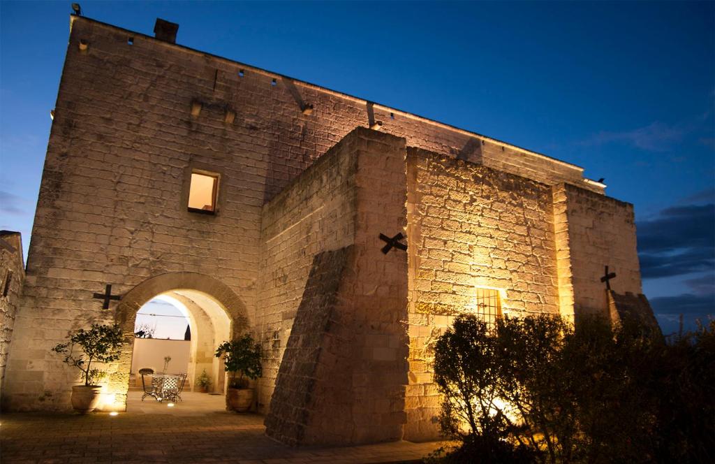 a large stone building with an archway at Masseria La Millenaria in San Foca