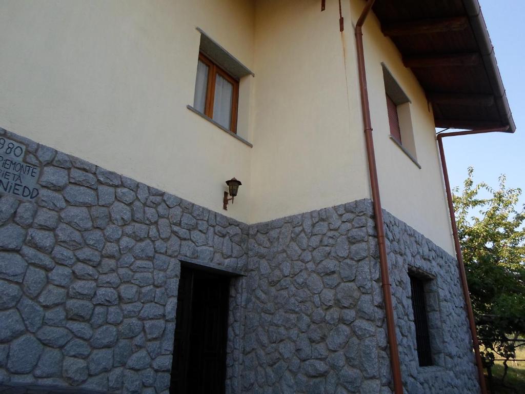 un edificio con un muro in pietra con porta e finestre di Casa Nicola a Rapone