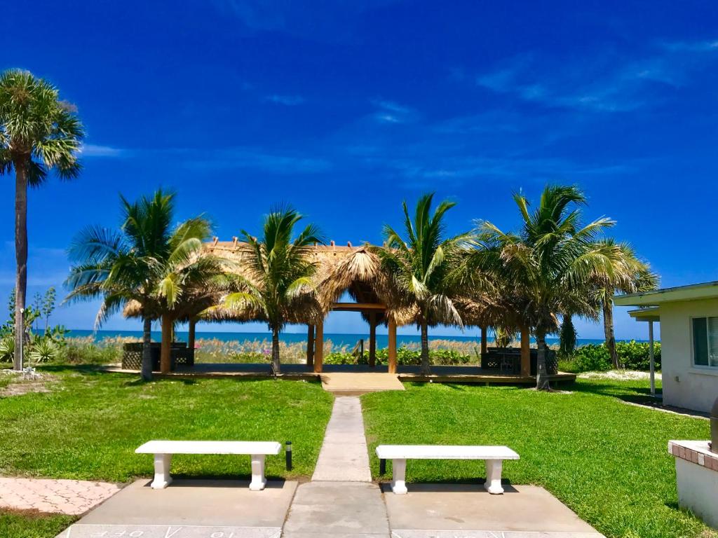 dos bancos en un parque con palmeras en Casey Key Resort - Gulf Shores, en Venice