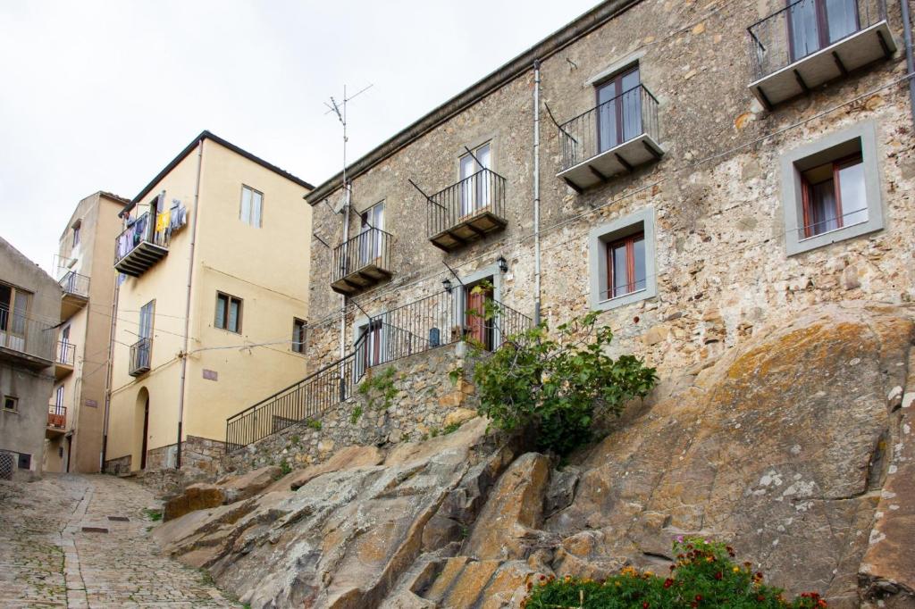 een oud stenen gebouw op een heuvel met gebouwen bij Casa vacanze Ai Valàti CIR 19082-037C20-6280 in Geraci Siculo