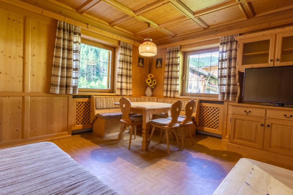 - une salle à manger avec une table, des chaises et une télévision dans l'établissement Home in the Alps, à Racines