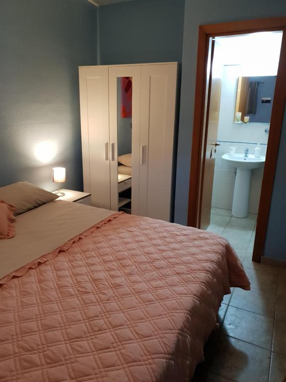 una camera con letto e un bagno con lavandino di CUCARACHA BUNGALOW a Catania
