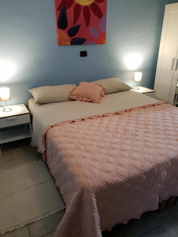 a bedroom with a large bed with two night stands at Rooms in the Beach in Catania