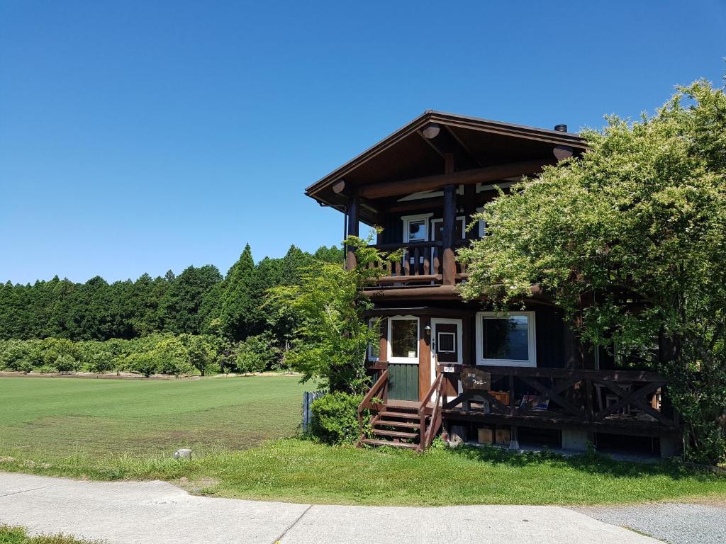 Cabaña de madera con porche y árbol en Ryoshuku Lassi / Vacation STAY 47925, en Koga
