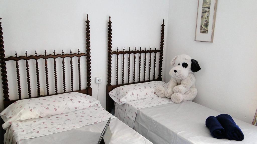 un perro de peluche sentado en dos camas en una habitación en Ca La Roseta, en Castellfollit de la Roca