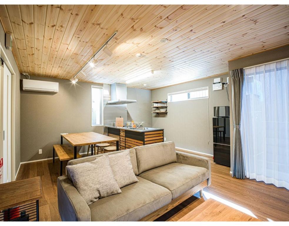 a living room with a couch and a dining room at Rakuten STAY HOUSE x WILL STYLE Matsue 103 in Matsue
