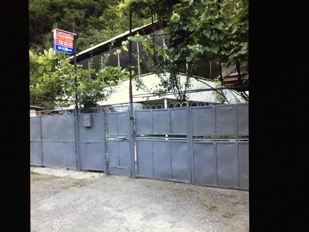 a blue fence with a sign on top of it at Guest House "SVANETI" in Lentekhi
