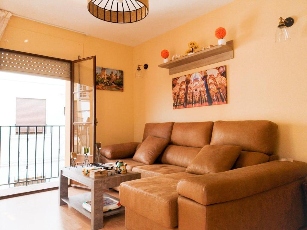 een woonkamer met een bruine bank en een tafel bij Apartamentos Ruz in Córdoba