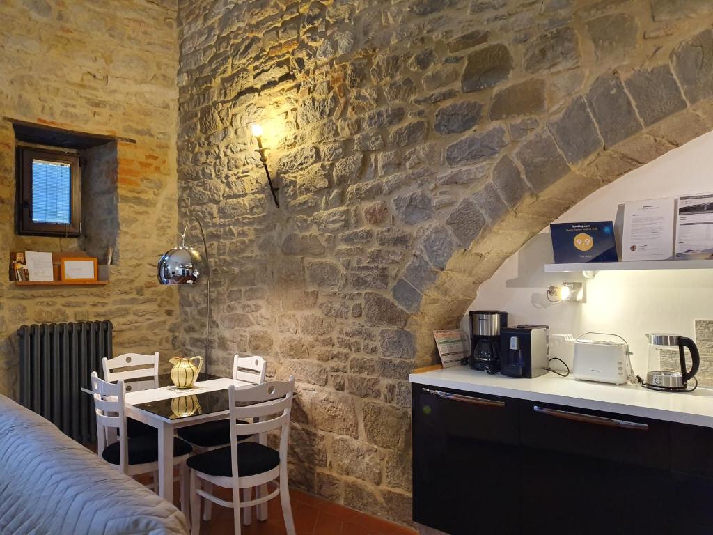 una cucina e una sala da pranzo con parete in pietra di The Arch a Cortona
