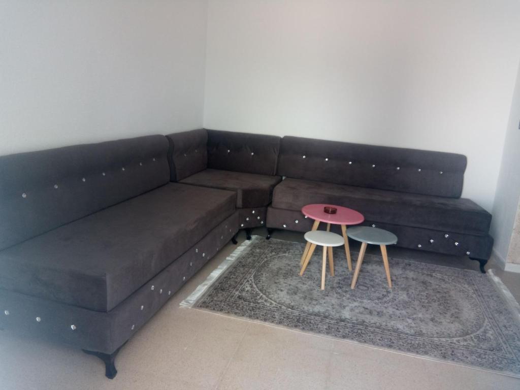 un sofá marrón con 2 sillas y una mesa en Appartement à Houmt Souk Jerba en Houmt El Souk