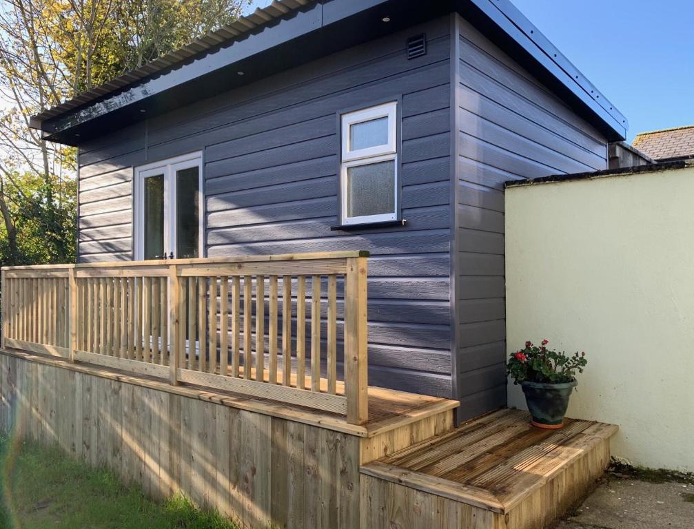 a tiny house with a wooden deck at The Garden room in Derry Londonderry