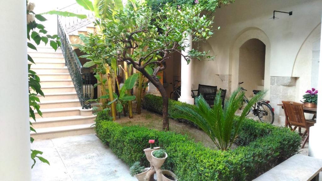 einen Innenhof mit einem Baum und einer Treppe in einem Gebäude in der Unterkunft Palazzo Rossi suite in Canosa di Puglia