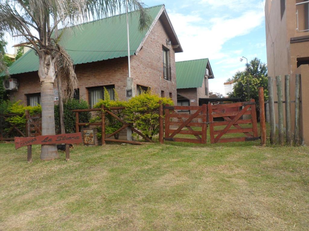 una valla de madera frente a una casa en GRIMALDI en Colón