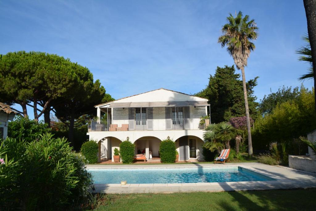 een huis met een zwembad en een palmboom bij Ramatuelle, Pampelonne, villa in Saint-Tropez