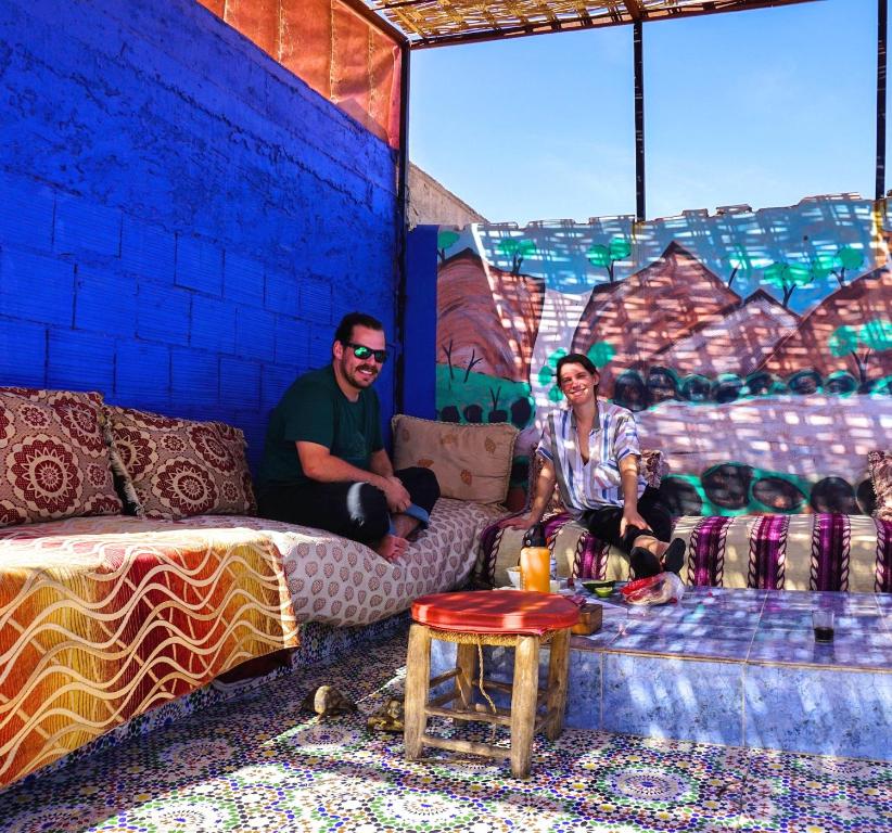 Ein Mann und eine Frau sitzen in einem Zimmer in der Unterkunft Hostel Marrakech Rouge in Marrakesch