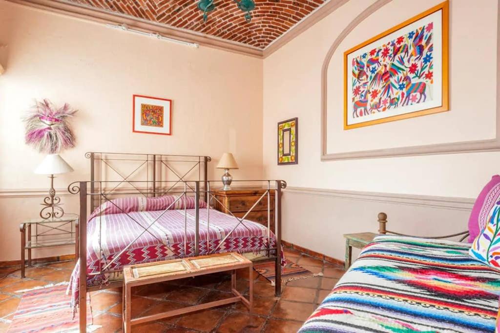a bedroom with a metal bed and a couch at Great 2 Bedroom apt @ the middle of everything in San Miguel de Allende