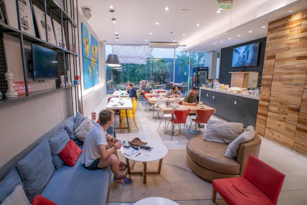 a restaurant with people sitting on couches and tables at America Del Sur Hostel Buenos Aires in Buenos Aires