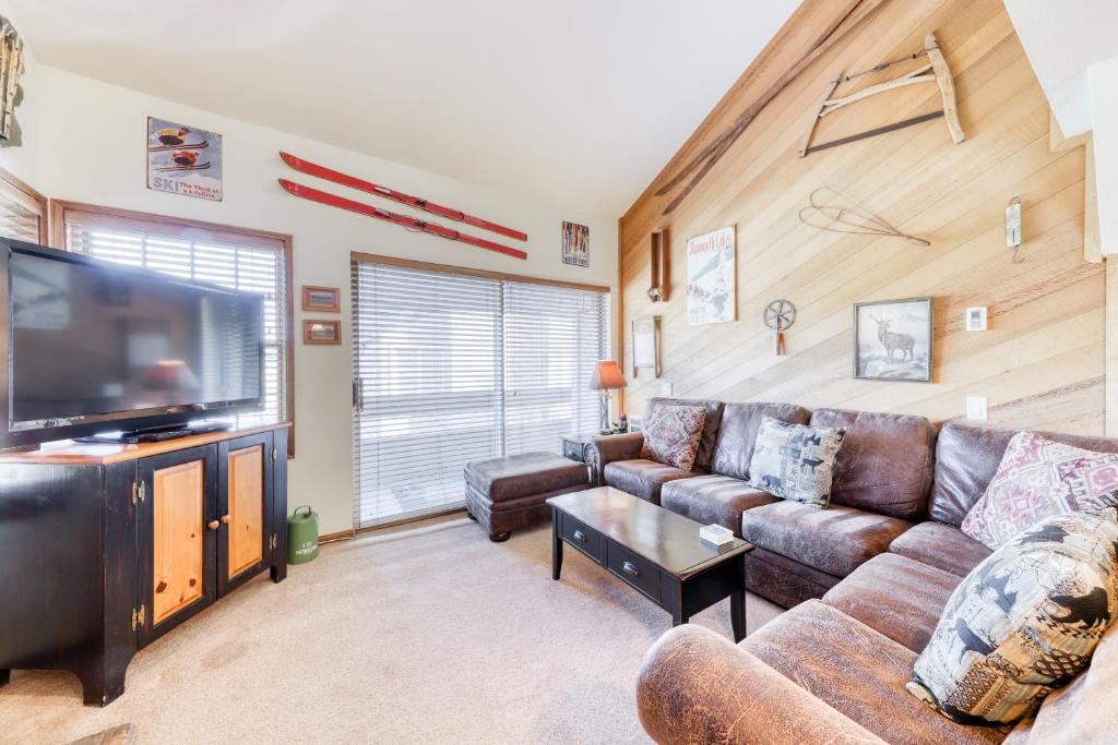 a living room with a couch and a flat screen tv at Sierra Megeve in Mammoth Lakes