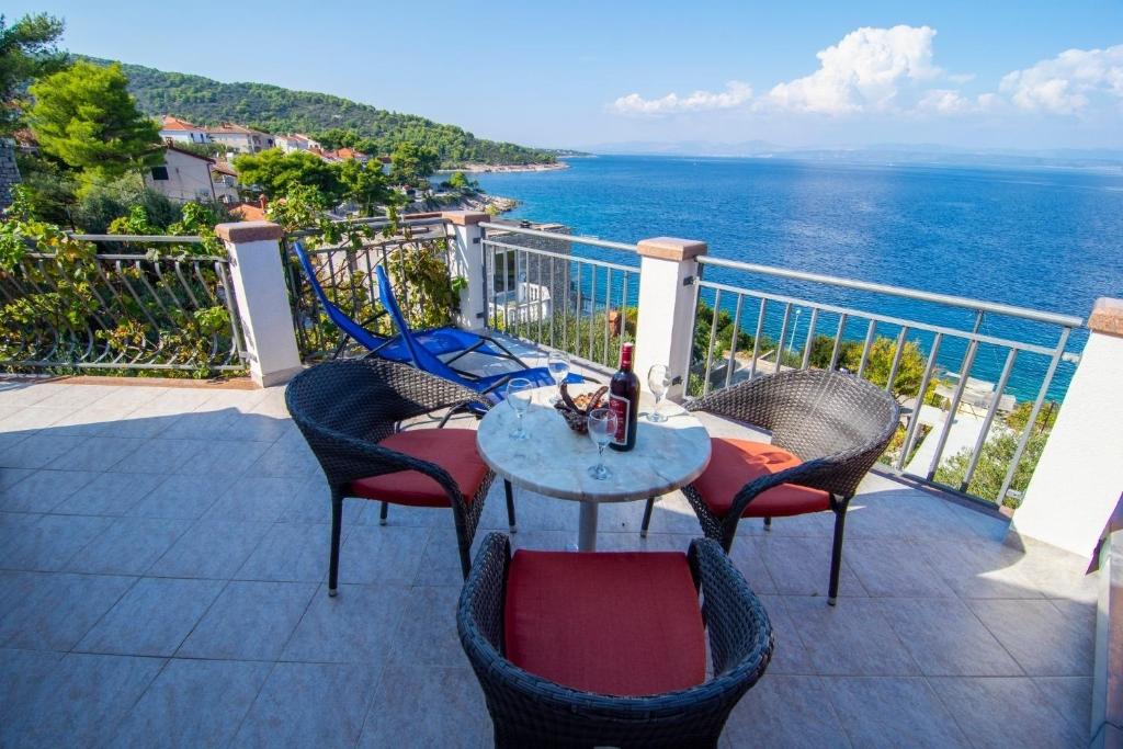 una mesa y sillas en un balcón con vistas al océano en Apartments Mari-peaceful and quiet, en Stomorska