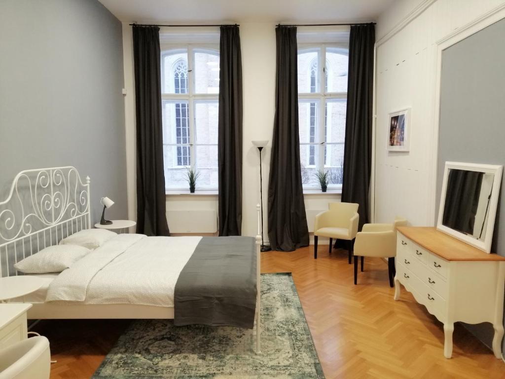 - une chambre avec un lit, un bureau et des fenêtres dans l'établissement FilinHome Zmaj Jovina Suite, à Novi Sad