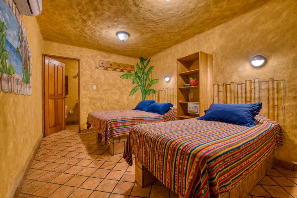 1 dormitorio con 2 camas en una habitación en El Sano Banano Beachside Hotel, en Montezuma